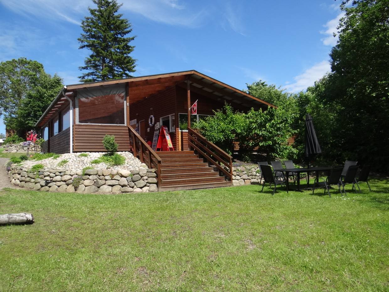 Holzhütte mit einer höher gelegenen Terrasse am Kanuverleih