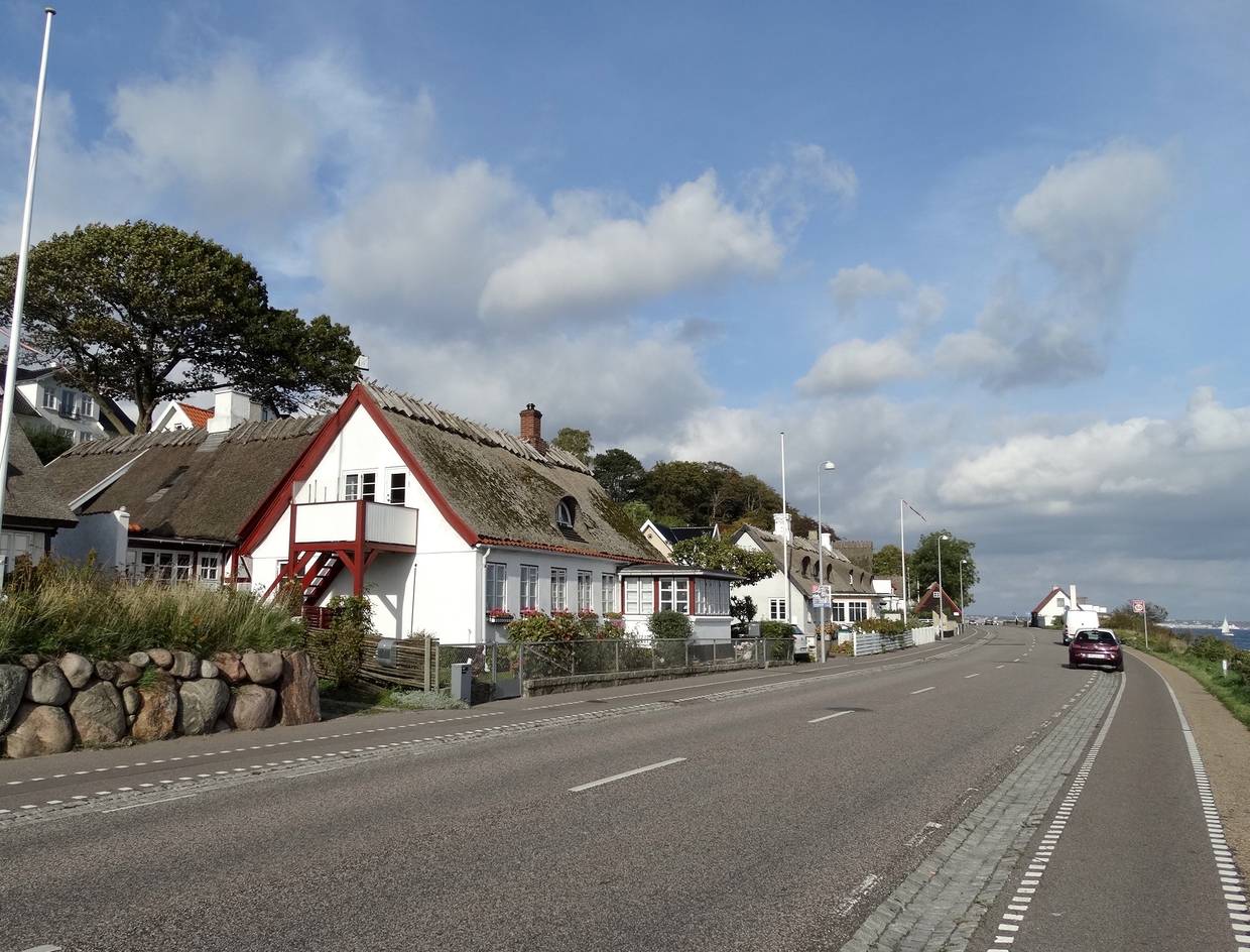 Reetdachhäuser an einer Küstenstraße