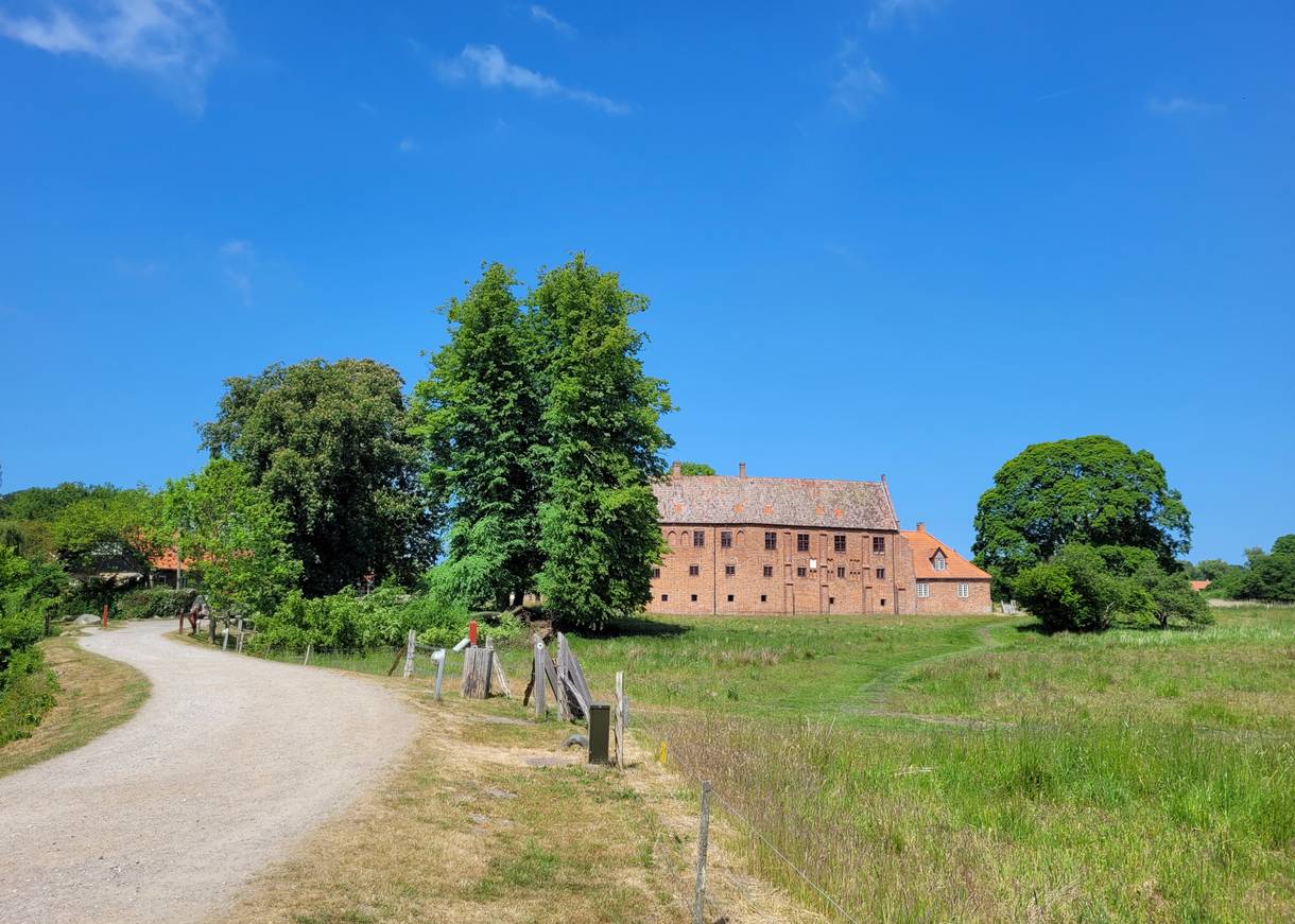Rest eines roten Backsteinkloster auf eine üppig grünen Wiese