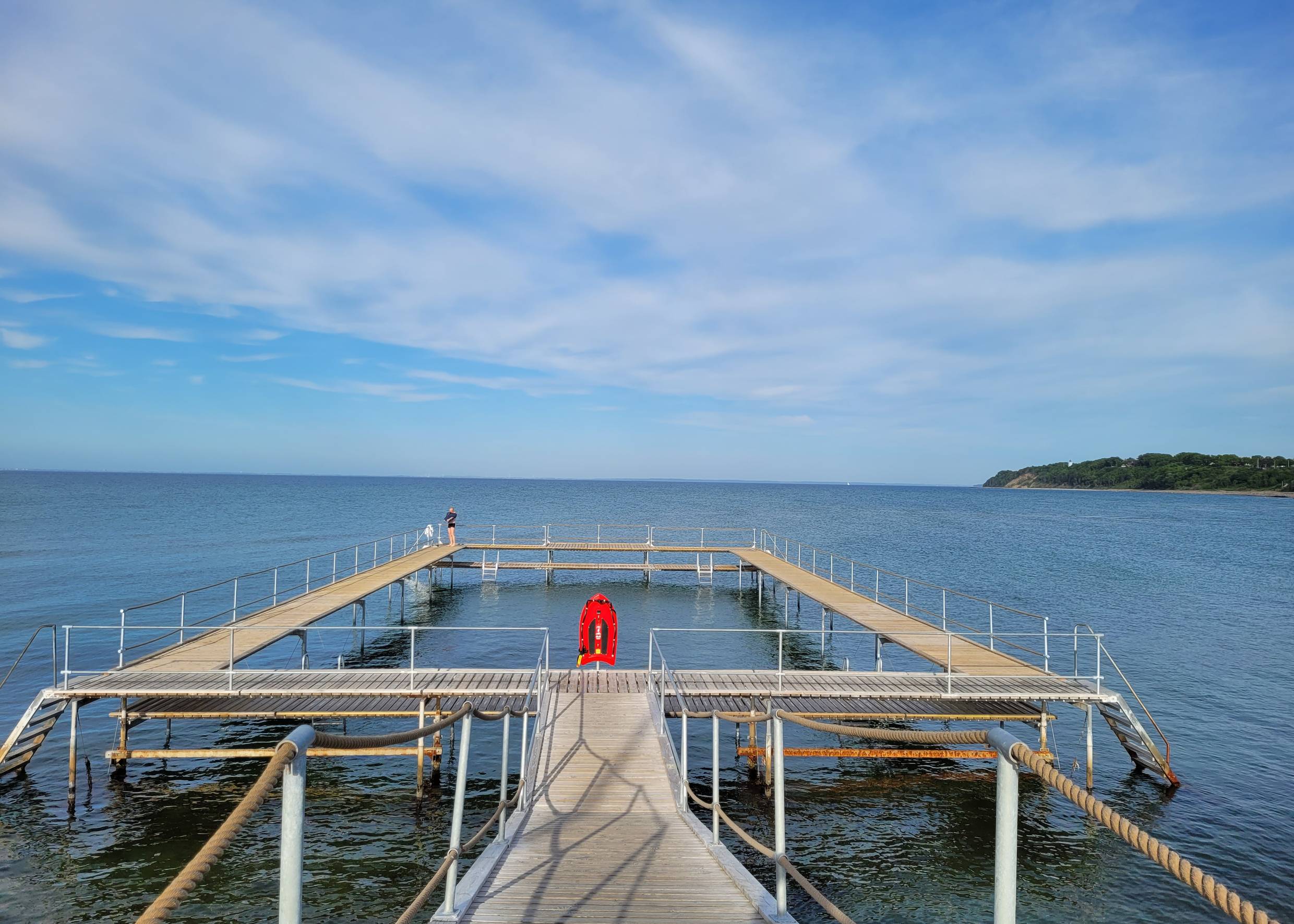 Im Viereck gebauter Badesteg, in Gilleleje im Hintergrund grüne Küste