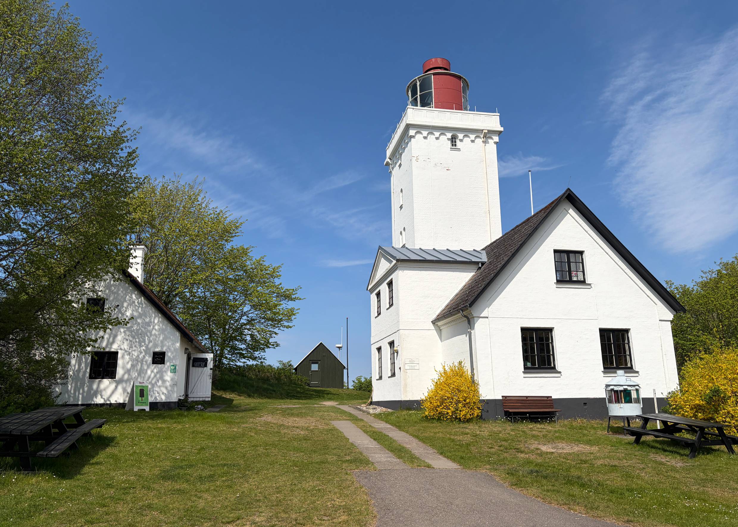 Weißer, eckiger Leuchtturm mit Nebengebäude