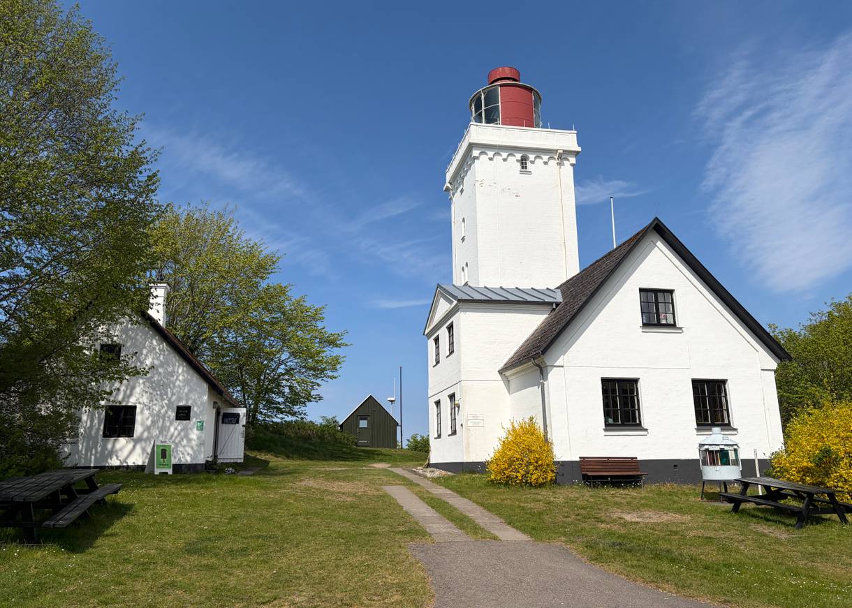 Weißer, eckiger Leuchtturm mit Nebengebäude
