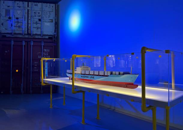 Museumsbesucher vor dem Modell eines großen Containerschiffs