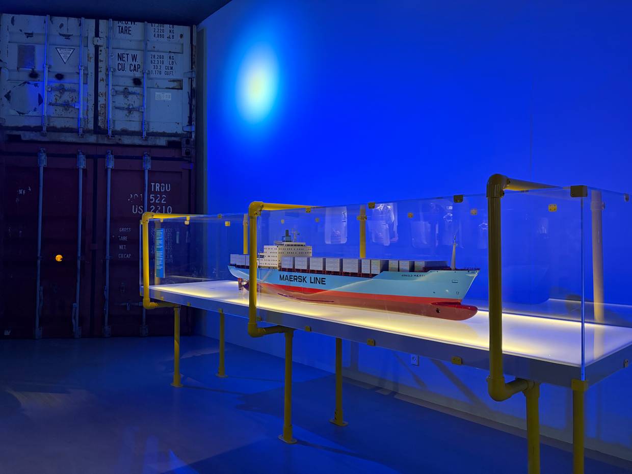 Museumsbesucher vor dem Modell eines großen Containerschiffs