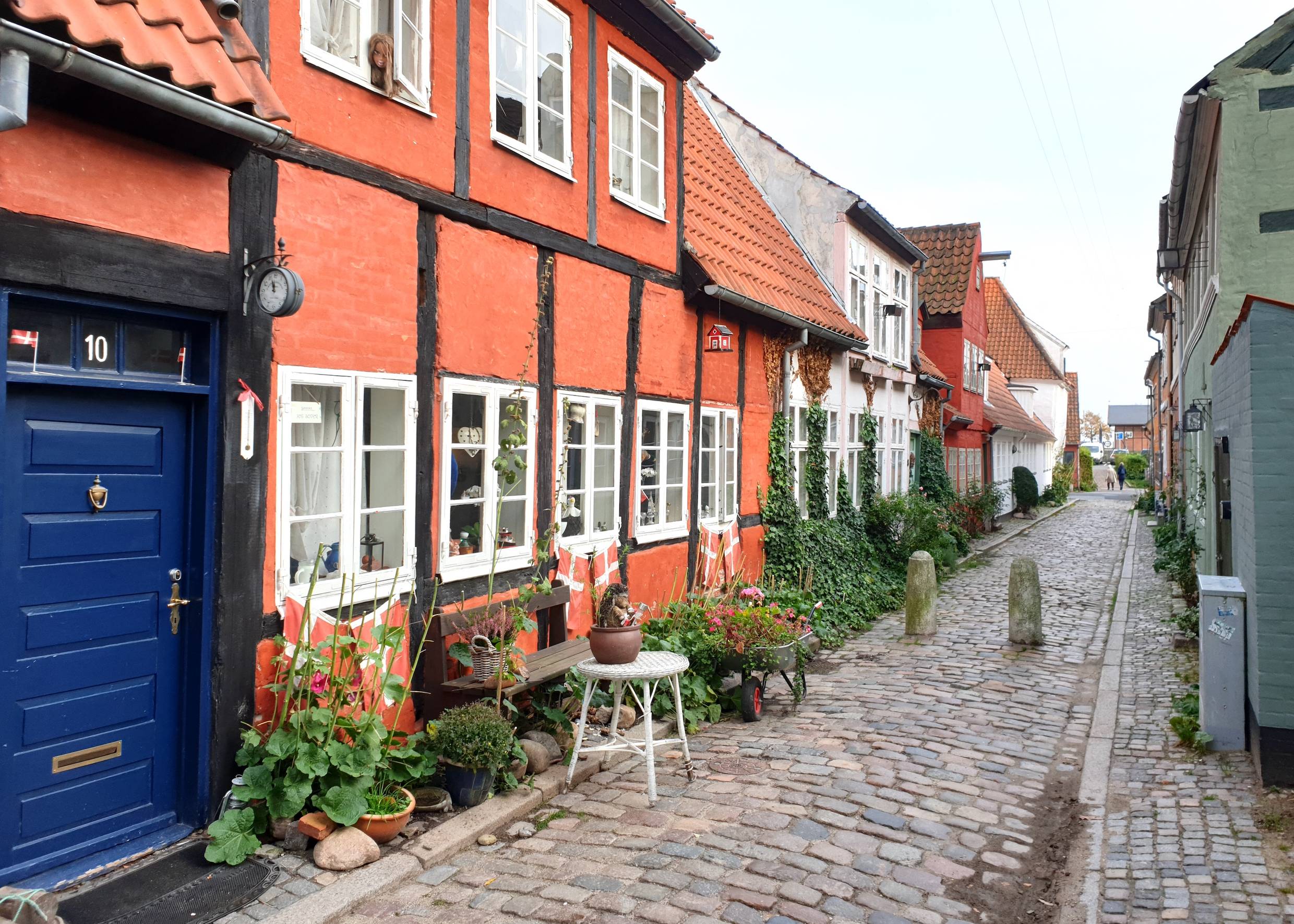 Schmale Kopfsteinpflastergasse mit rotenund weißen Fachwerkhäusern