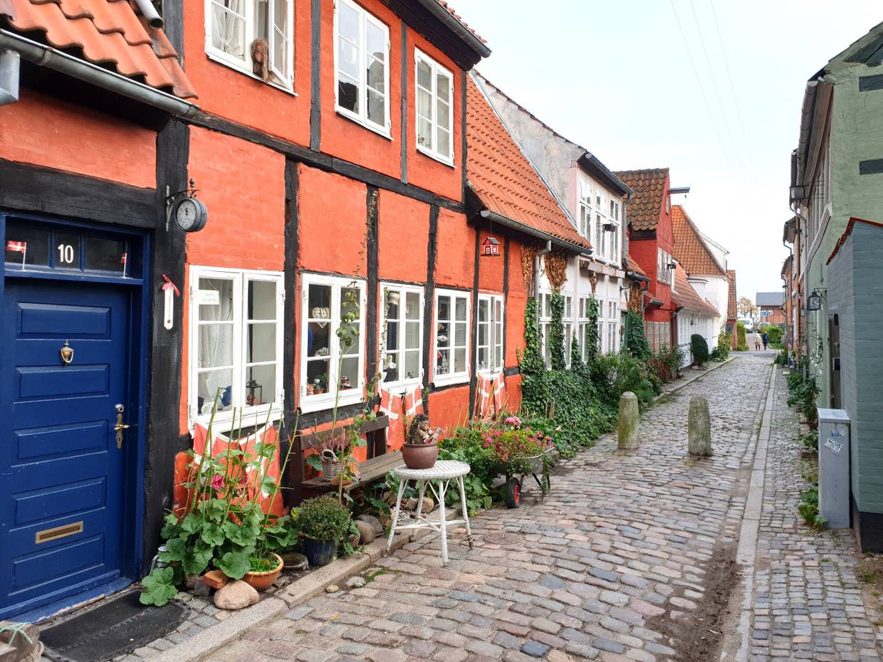 Schmale Kopfsteinpflastergasse mit rotenund weißen Fachwerkhäusern