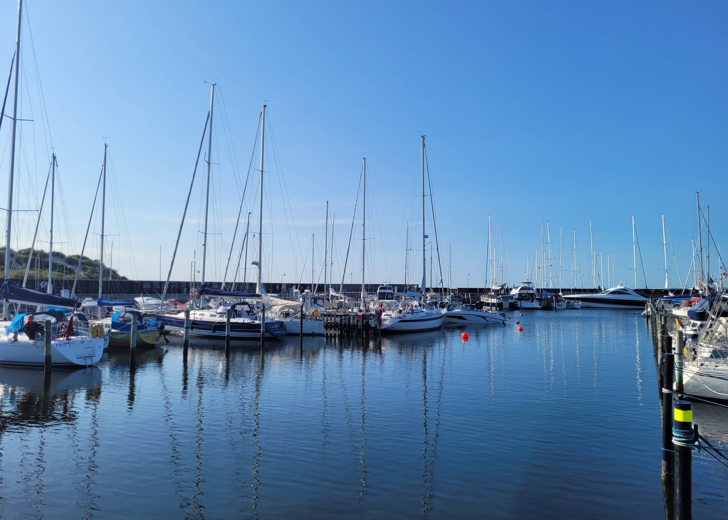 Blick auf einen Jachthafen, rechts und links große Segeljachten am Steg