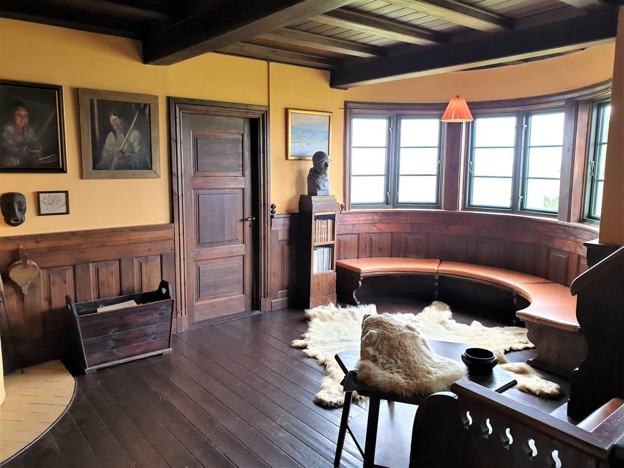 Wohnraum in einem Museum, viel dunkles Holz, Malerei, Schafsfelle
