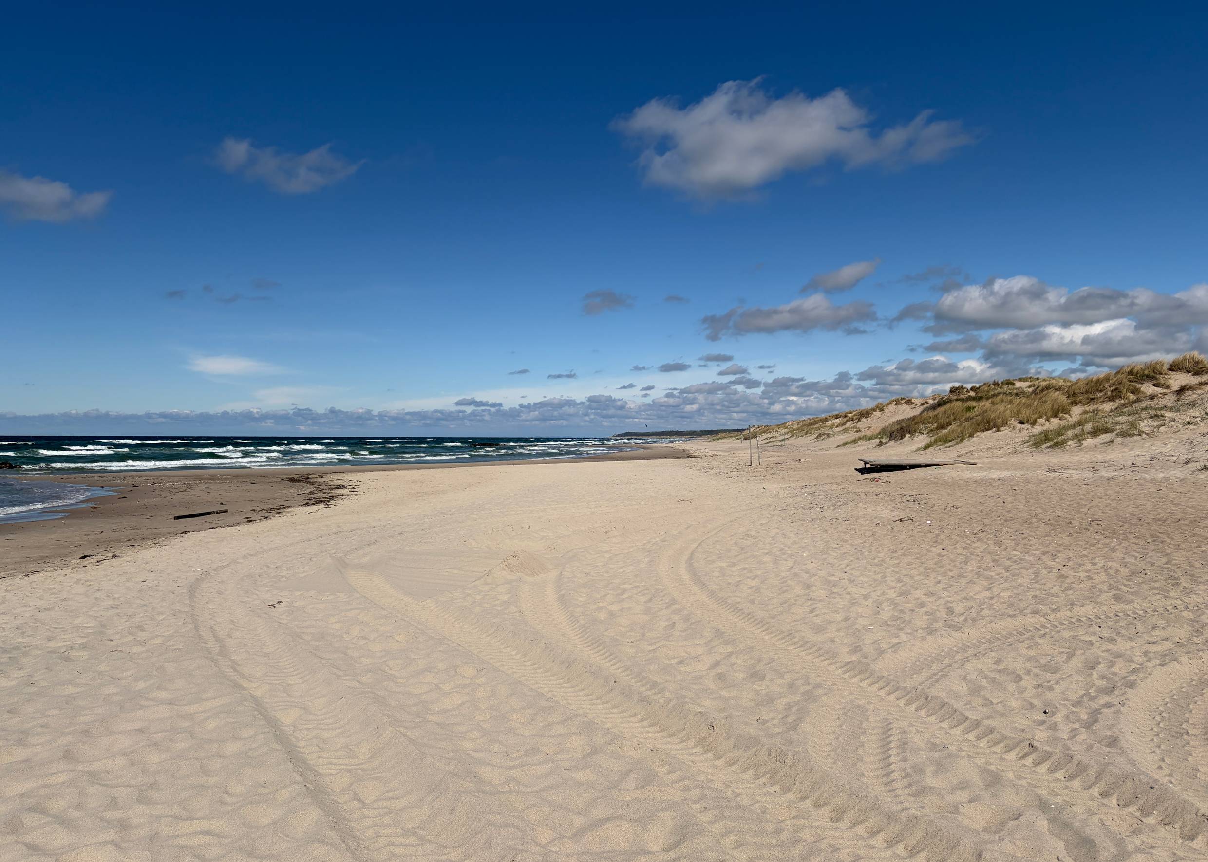 Blick auf einen breiten Sandstrand mit Badegästen