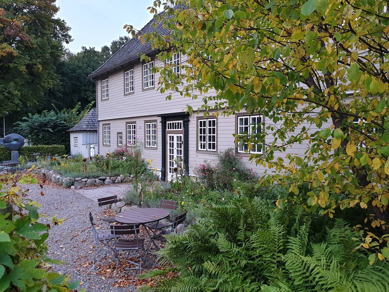 Grau vertäfeltes Landhaus in einem herbstlichen Garten