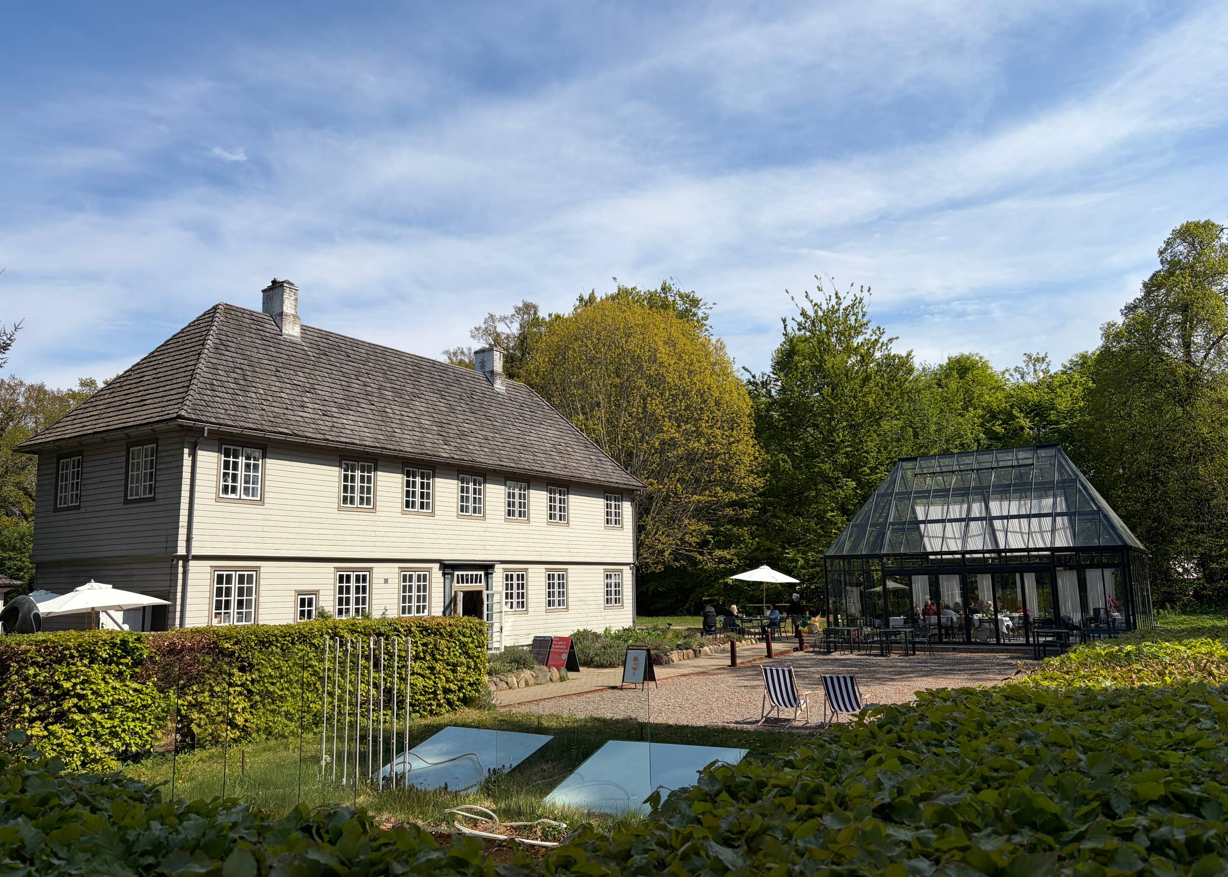 Museum in einem alten Holzgebäude mit gepflegter Parkanlage und Außengastronomie