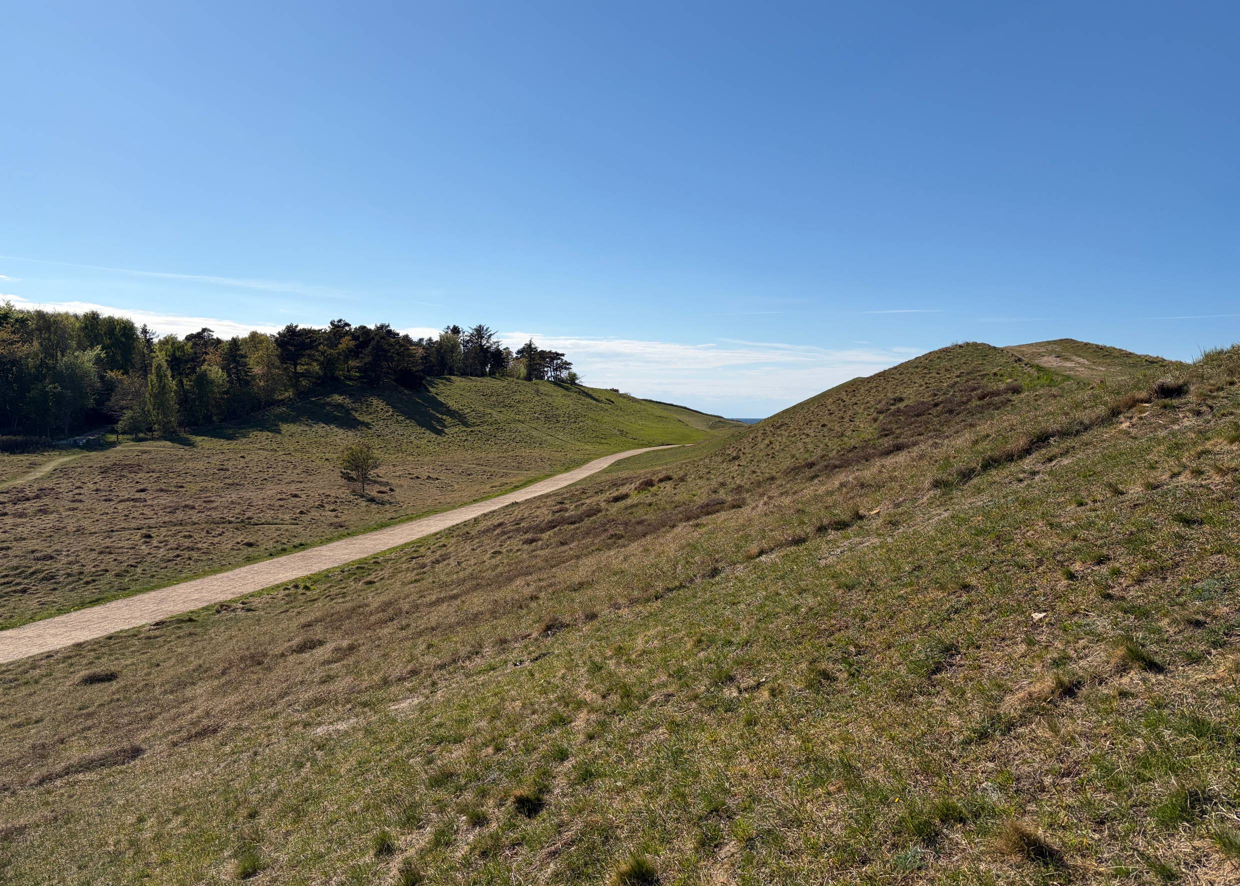 Fußweg zwischen grünen Hügeln zum Meer