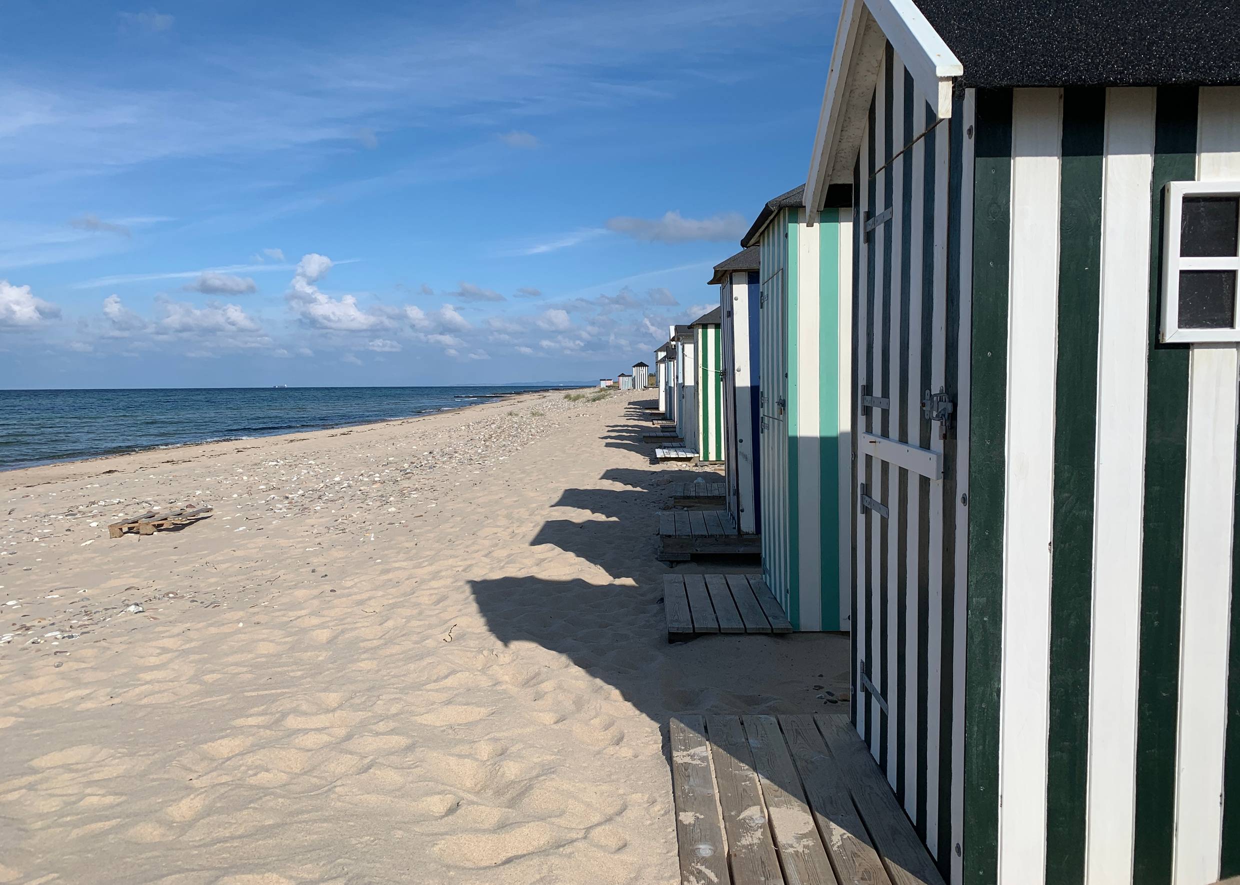 Hübsche Badehäuser aufgereit am weißen Strand