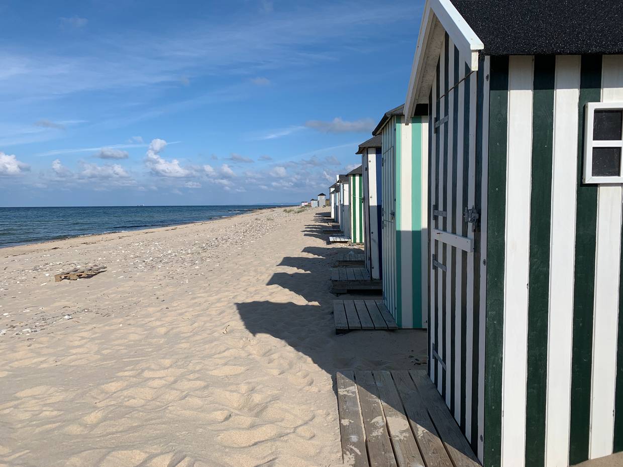 Hübsche Badehäuser aufgereit am weißen Strand