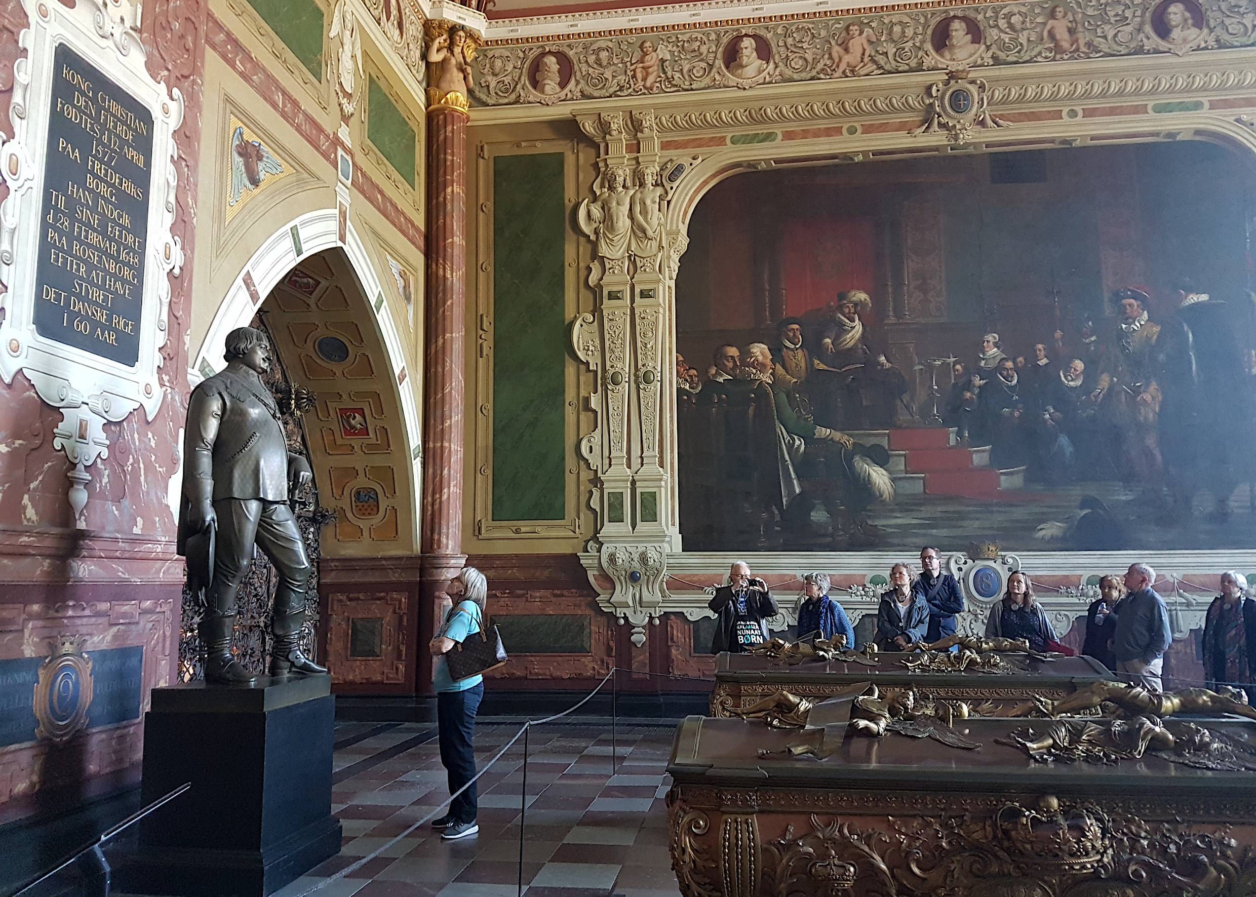 Besucher im Dom vor einer Skulptur, im Hintergrund ein Wandgemälde