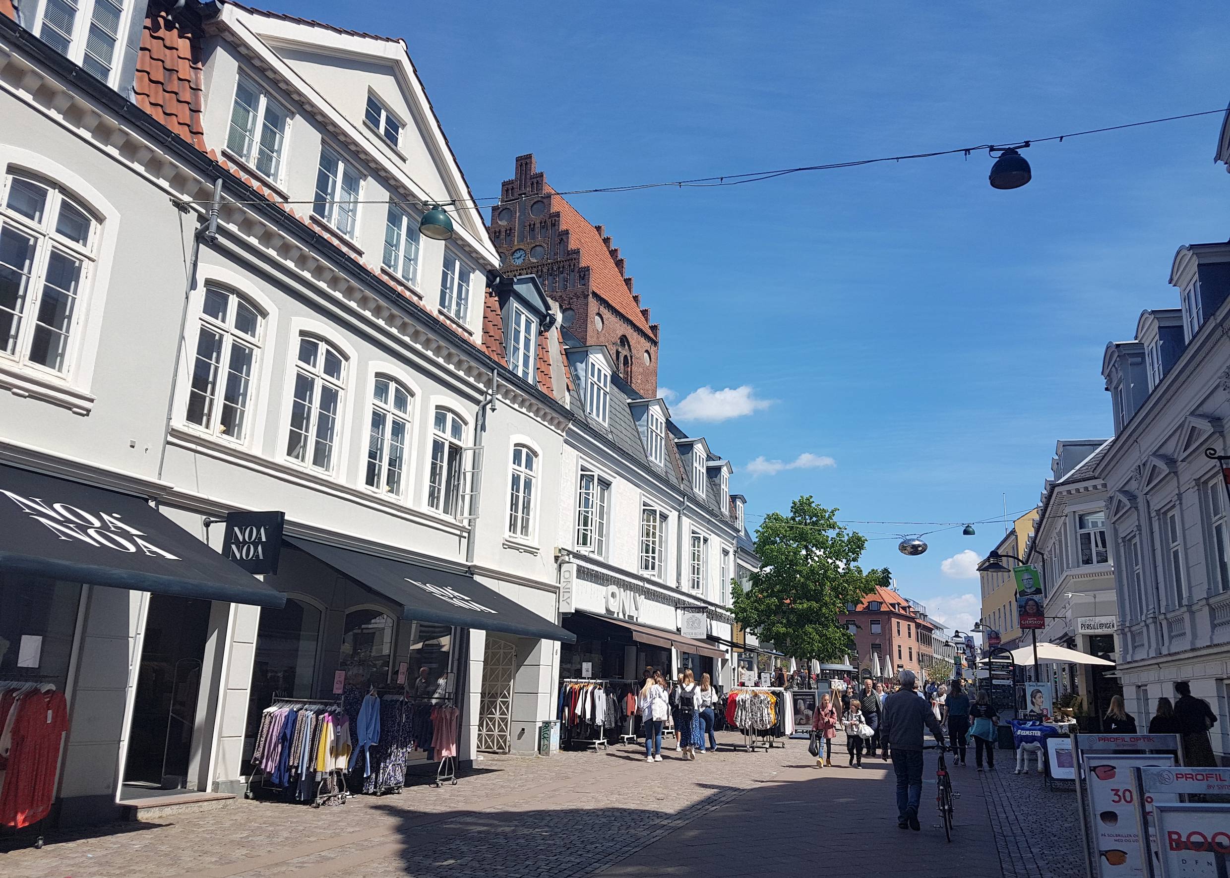 Blick auf die Fußgängerzone im Sonnenschein mit einigen Passanten