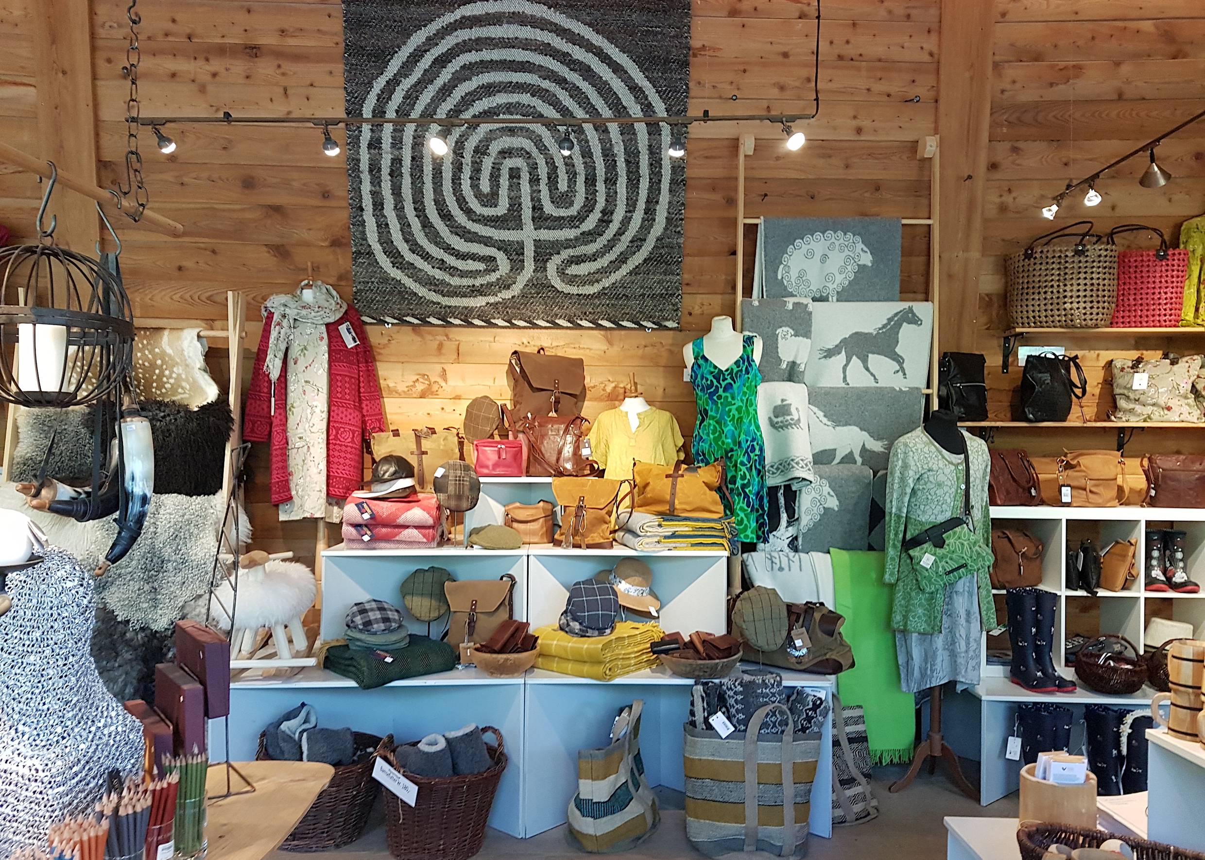Auslage im Museumshop, bunte Pullover und Taschen