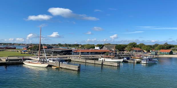 Kleiner Hafen mit Segelschiffen, im Hintergrund mehrere Gebäude