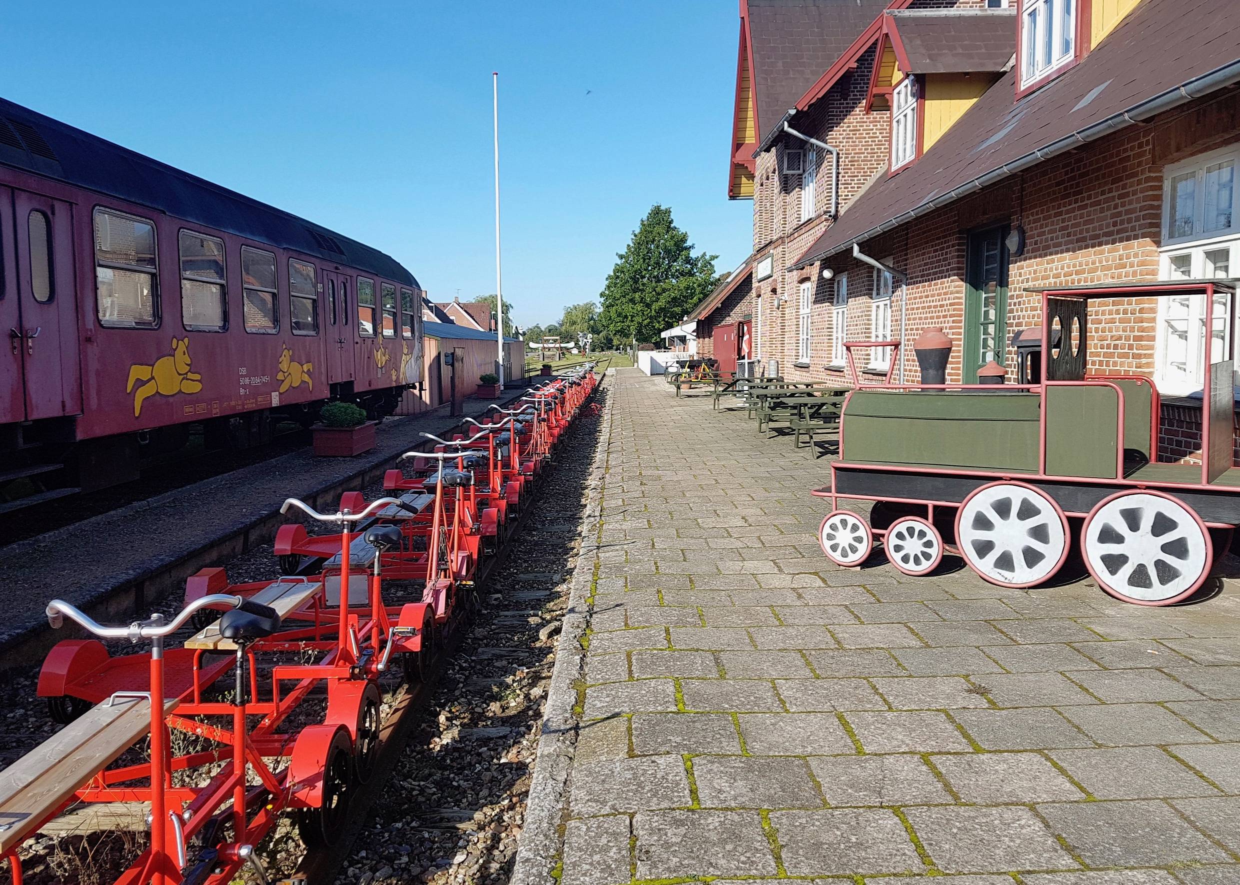 Ehemaliger Bahnsteig, an dem rote Schinenfahrräder stehen