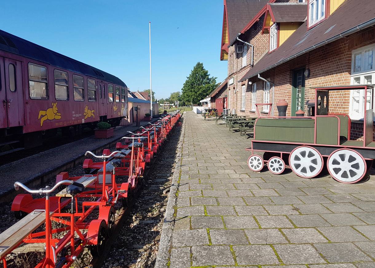 Ehemaliger Bahnsteig, an dem rote Schinenfahrräder stehen