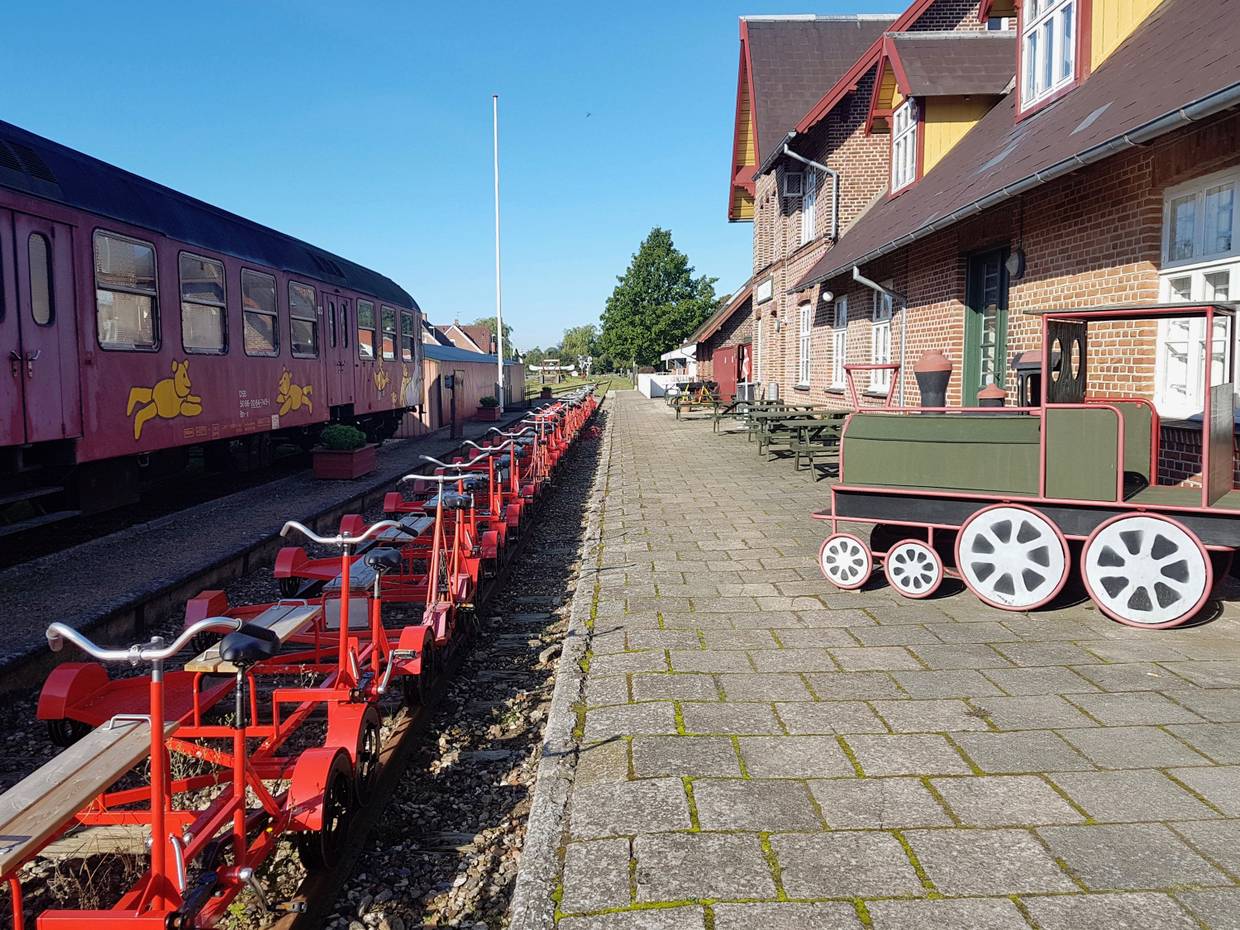 Ehemaliger Bahnsteig, an dem rote Schinenfahrräder stehen