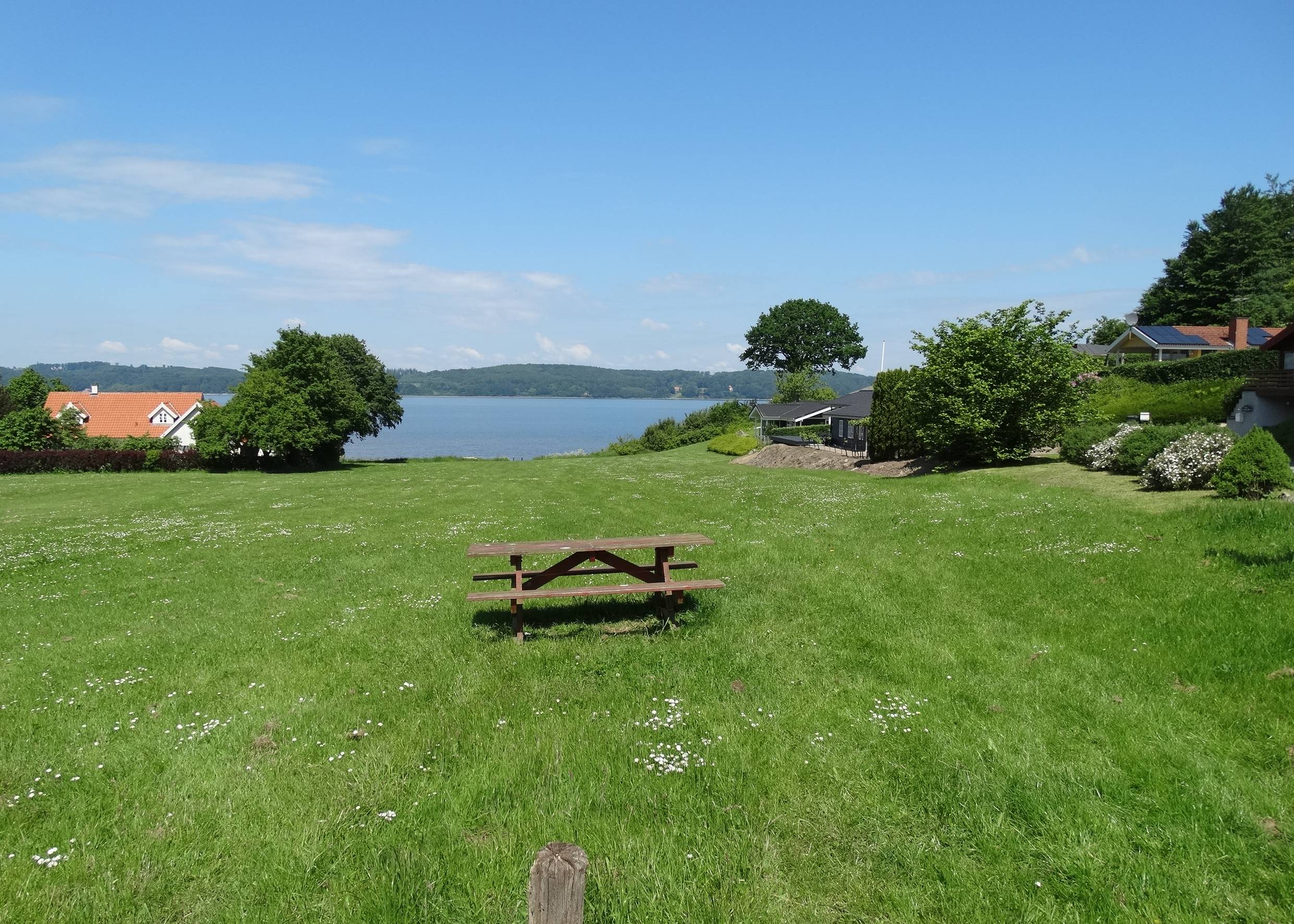Fjordblick von einem Hügel, auf der Wiese eine Picknickbank