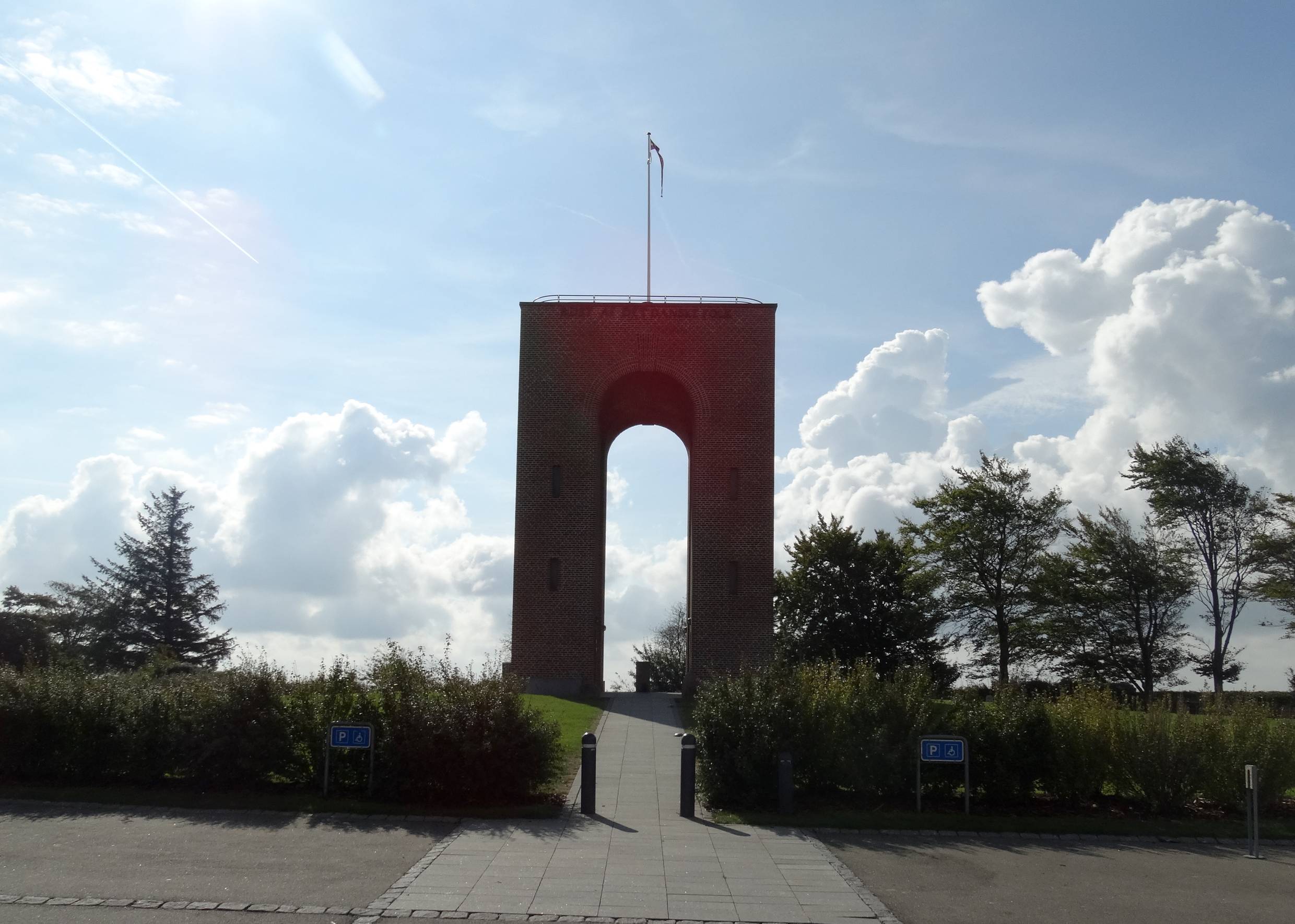 Schmaler hoher Torbogen mit einer Fahne auf dem Dach 