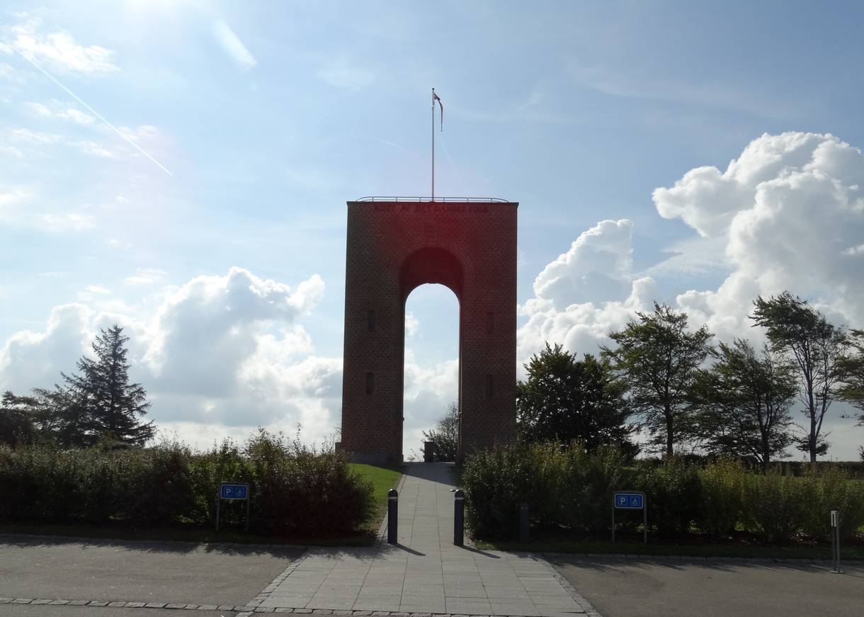 Schmaler hoher Torbogen mit einer Fahne auf dem Dach 