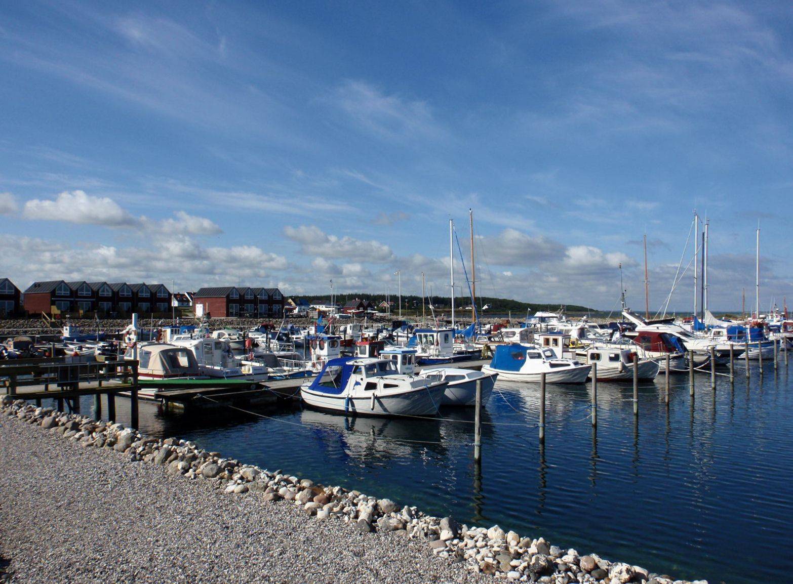 Bootssteg im Jachhafen sehr steiniges Ufer und Reihenhäuser im Huntergrund