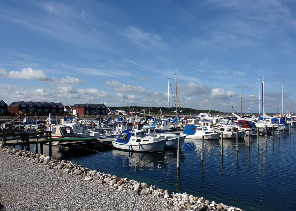 Bootssteg im Jachhafen sehr steiniges Ufer und Reihenhäuser im Huntergrund