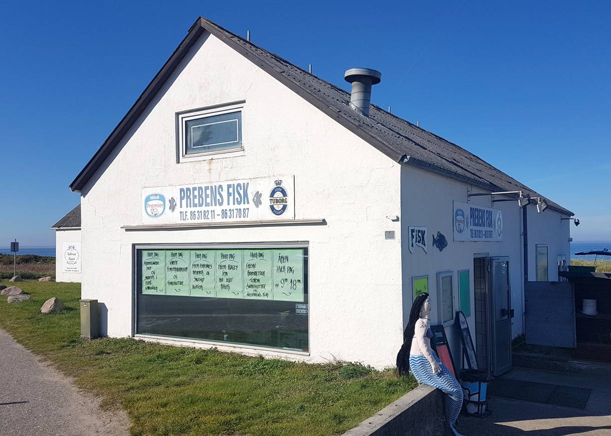 Älteres Fischgeschäft, davor eine gebastelte Nixenfigur