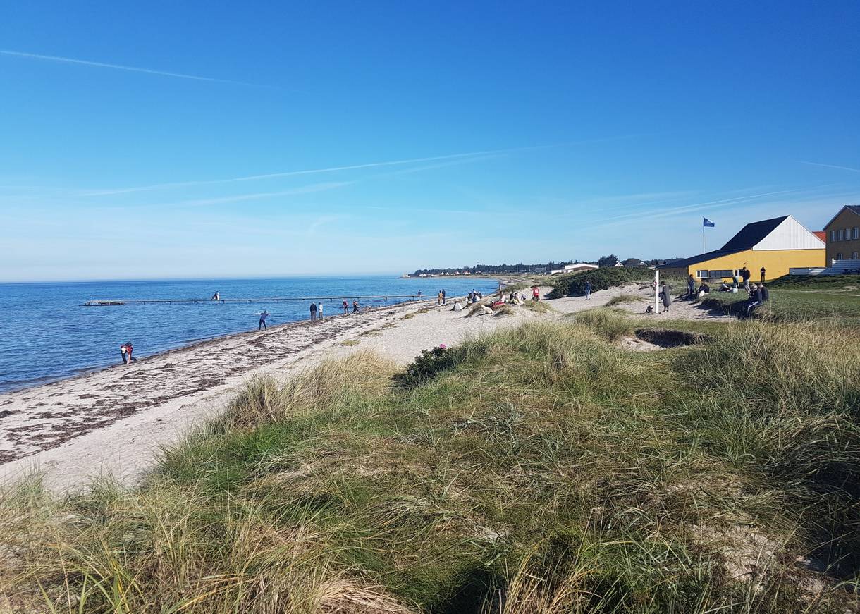 Blick auf den Sandstrand in Fjellerup vor einem Restaurant