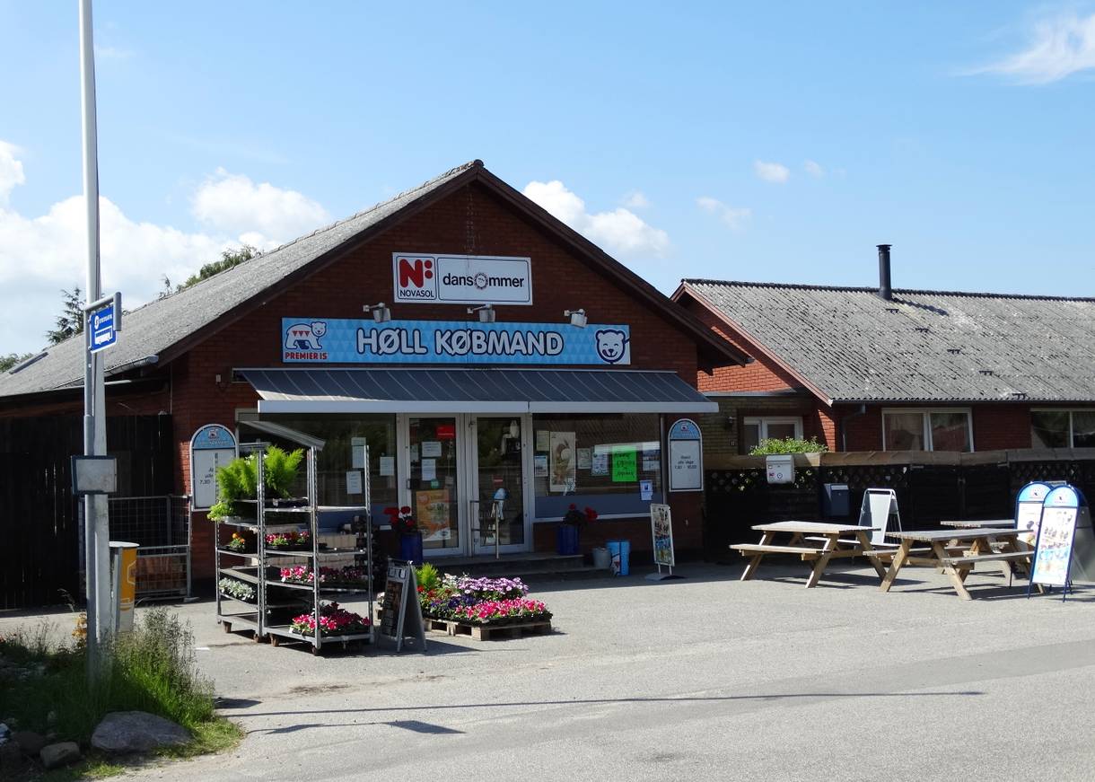 Schwarzes Holzhaus mit einem kleinen Lebensmittelladen
