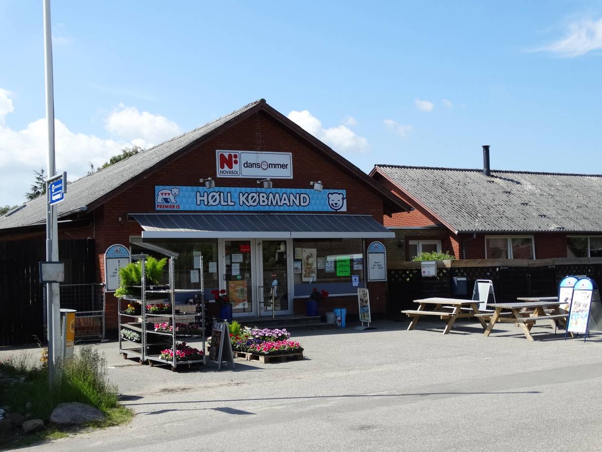 Schwarzes Holzhaus mit einem kleinen Lebensmittelladen