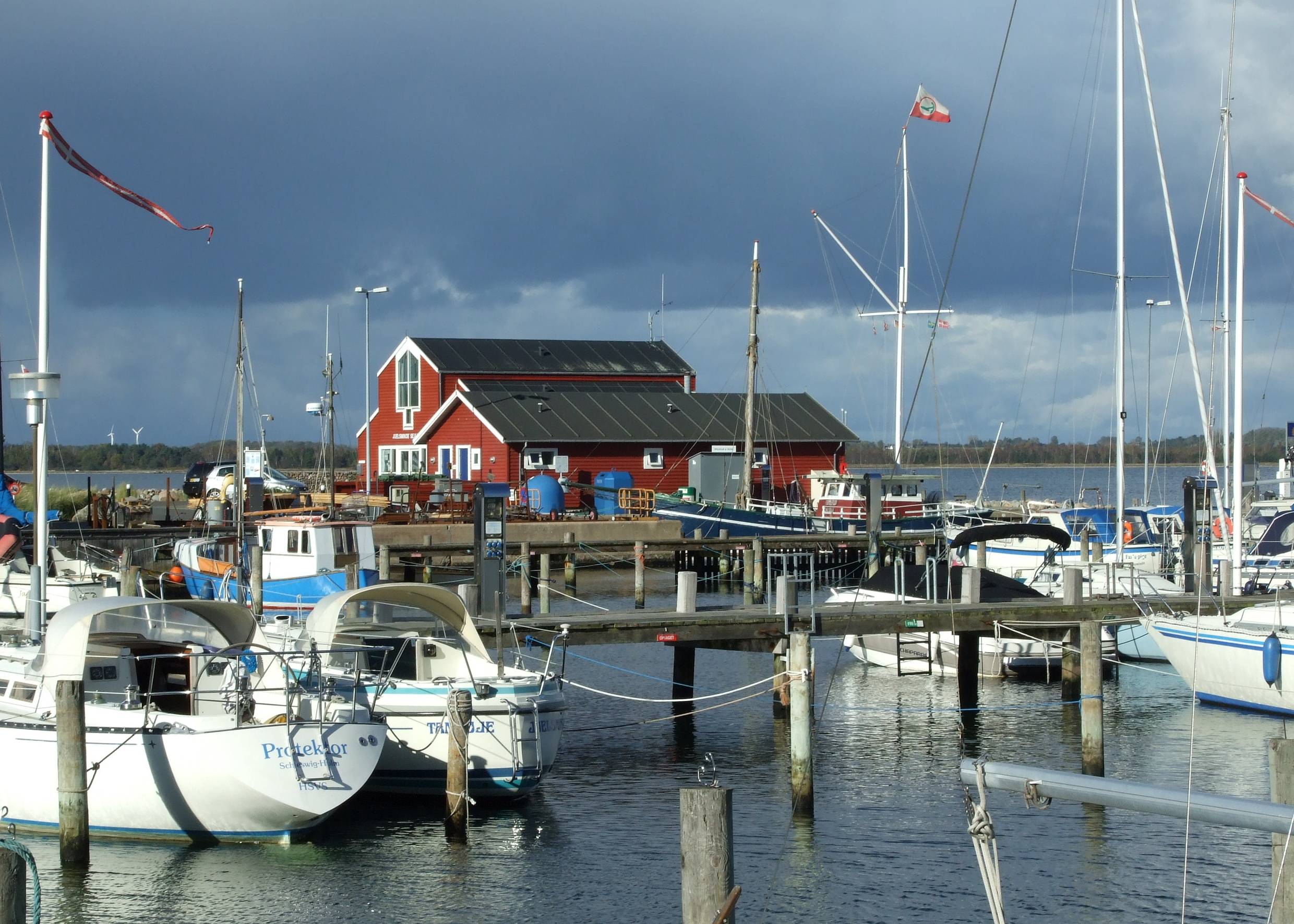 Segelboote in Hafen vor einem grauen Gewitterhimmel