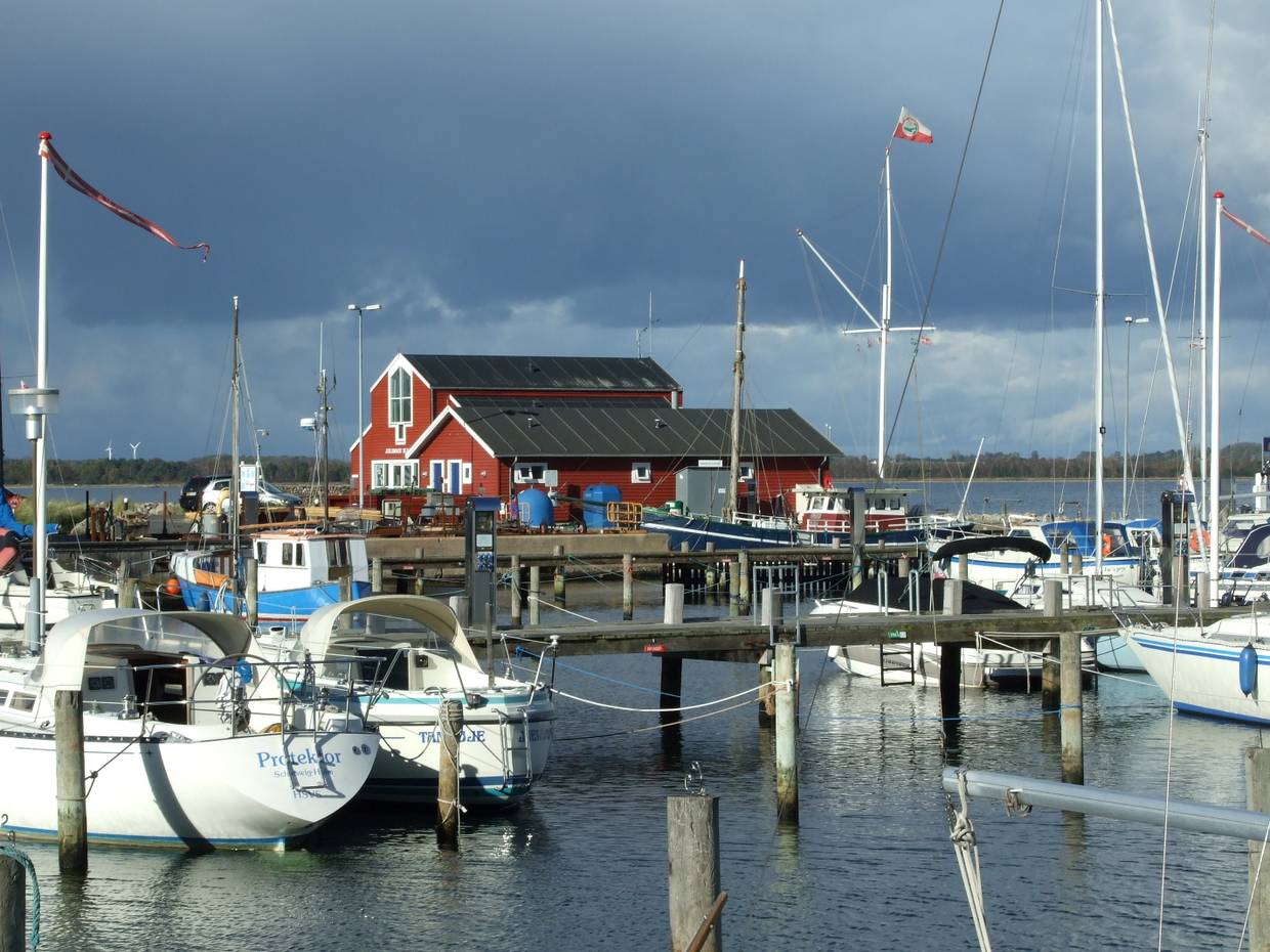 Segelboote in Hafen vor einem grauen Gewitterhimmel