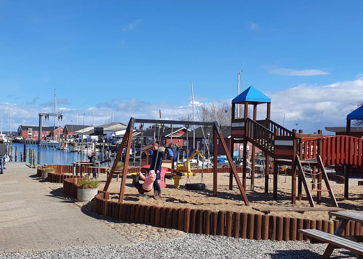 Spielgeräte und etwas Sand vor einem Restaurant