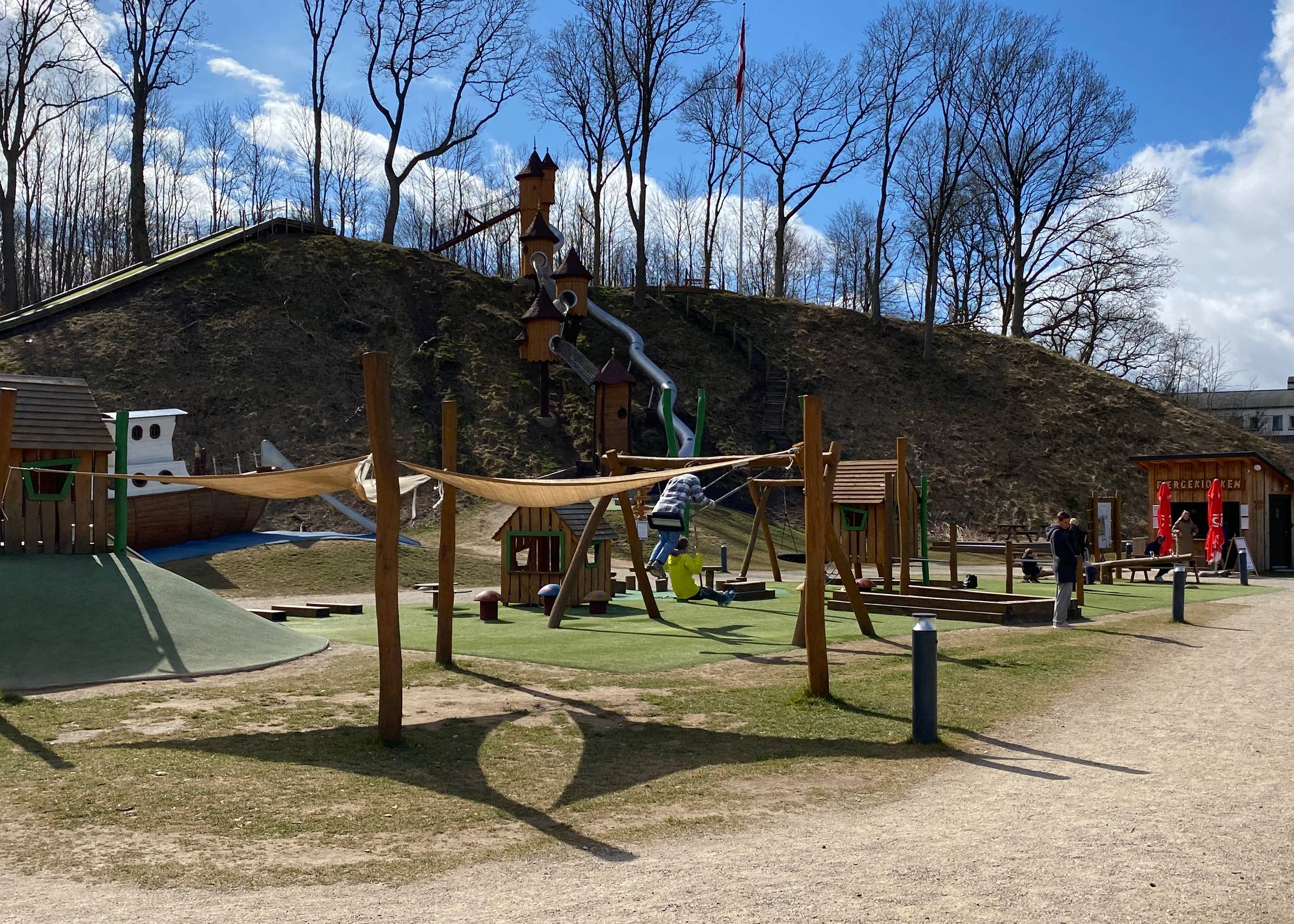 Spielplatz vor einem Hang mit spielenden Kindern