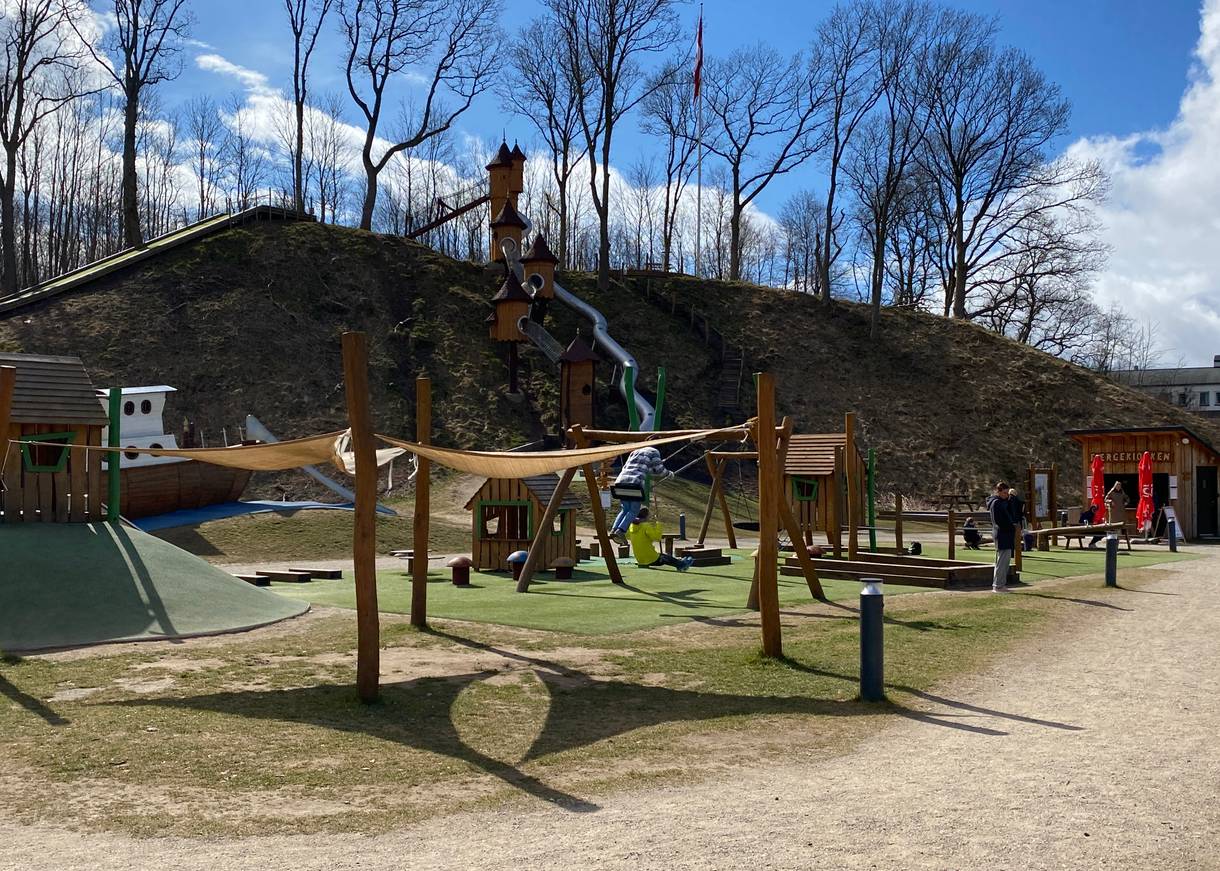 Spielplatz vor einem Hang mit spielenden Kindern