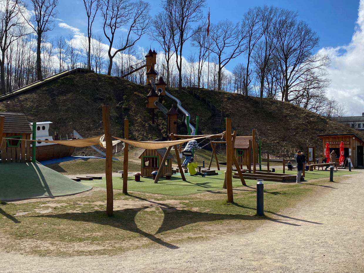Spielplatz vor einem Hang mit spielenden Kindern