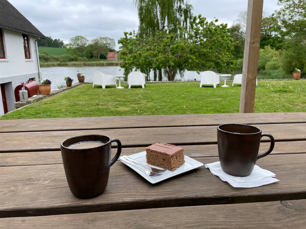 Gefüllte Kaffetassen und hausgemachter Kuchen mit Blick auf einem See