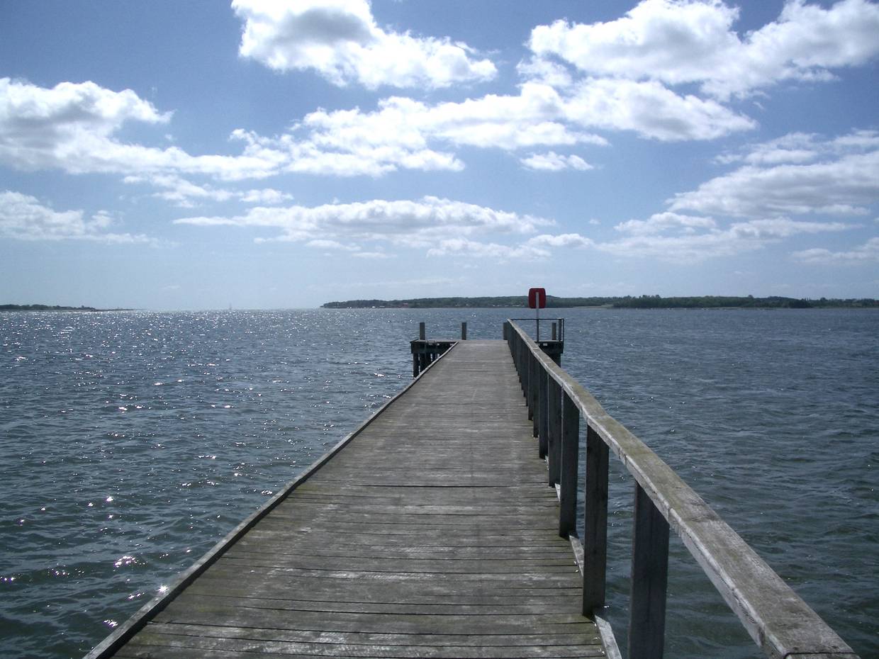 Holzsteg ber dem wasser, am Ende Platz der Anleger für eine Fähre