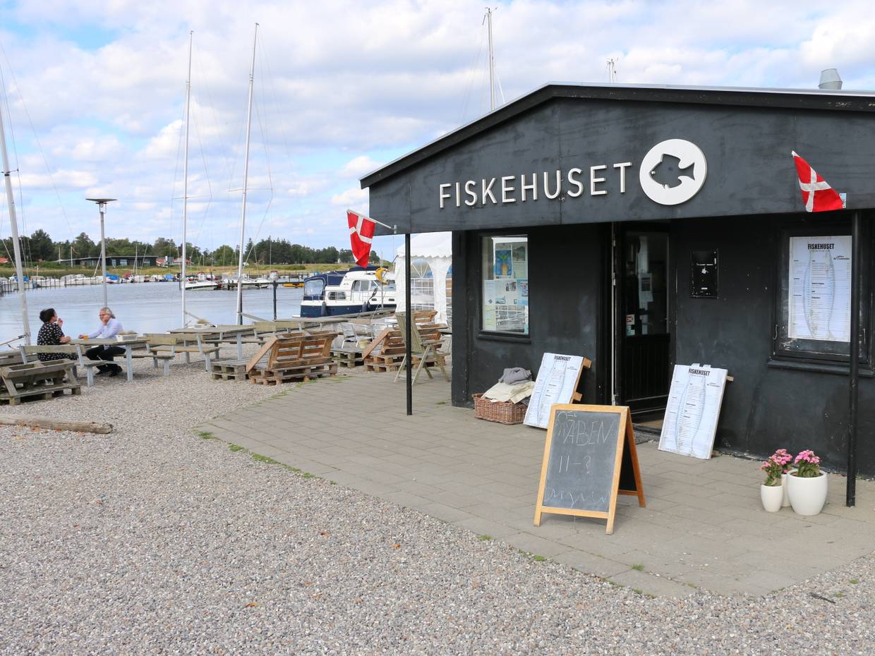 Schwarzes Holzhaus mit Fischlokal am Jachthafen