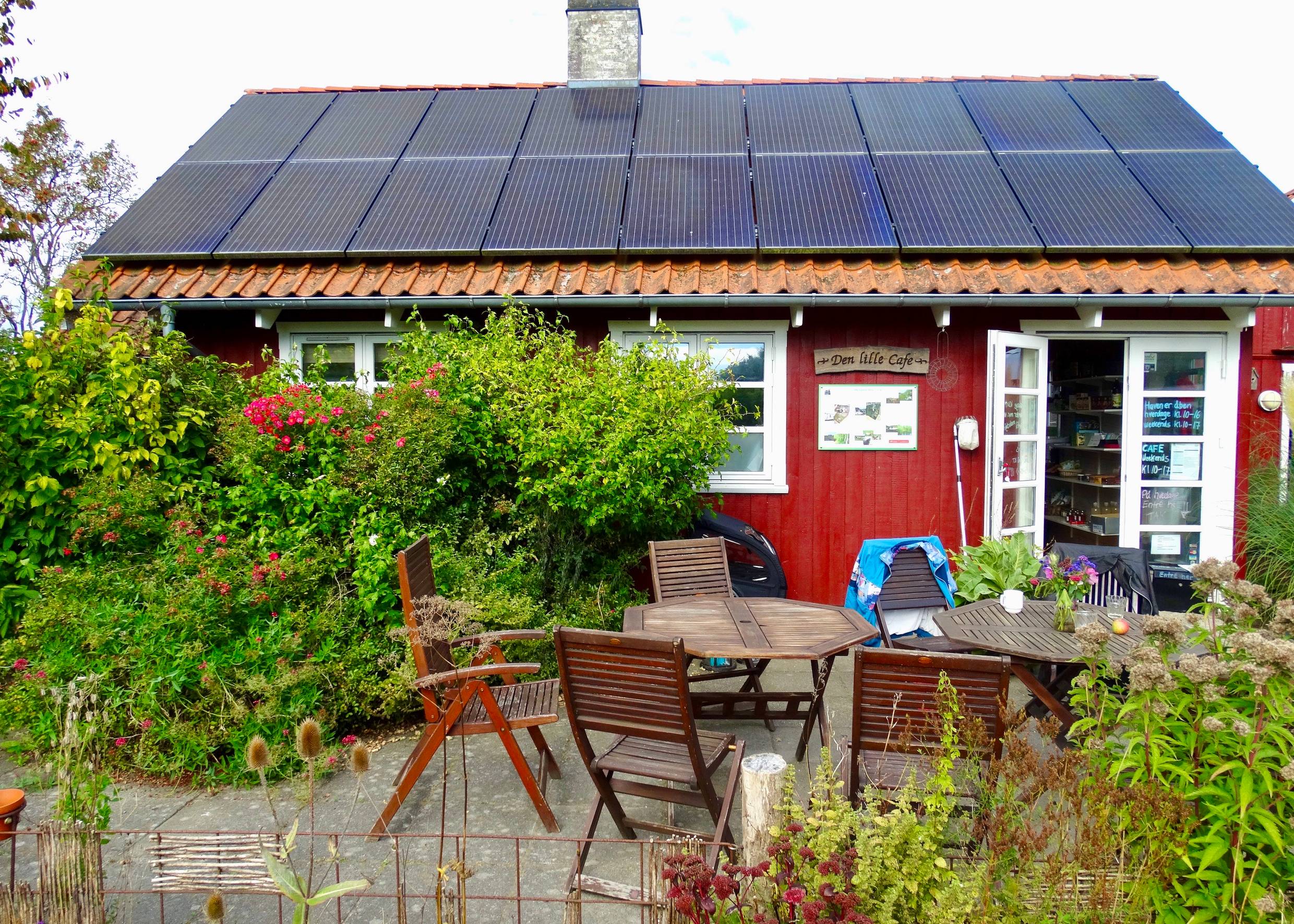 Rote Holzhütte mit Sitzplätzen vor der Tür