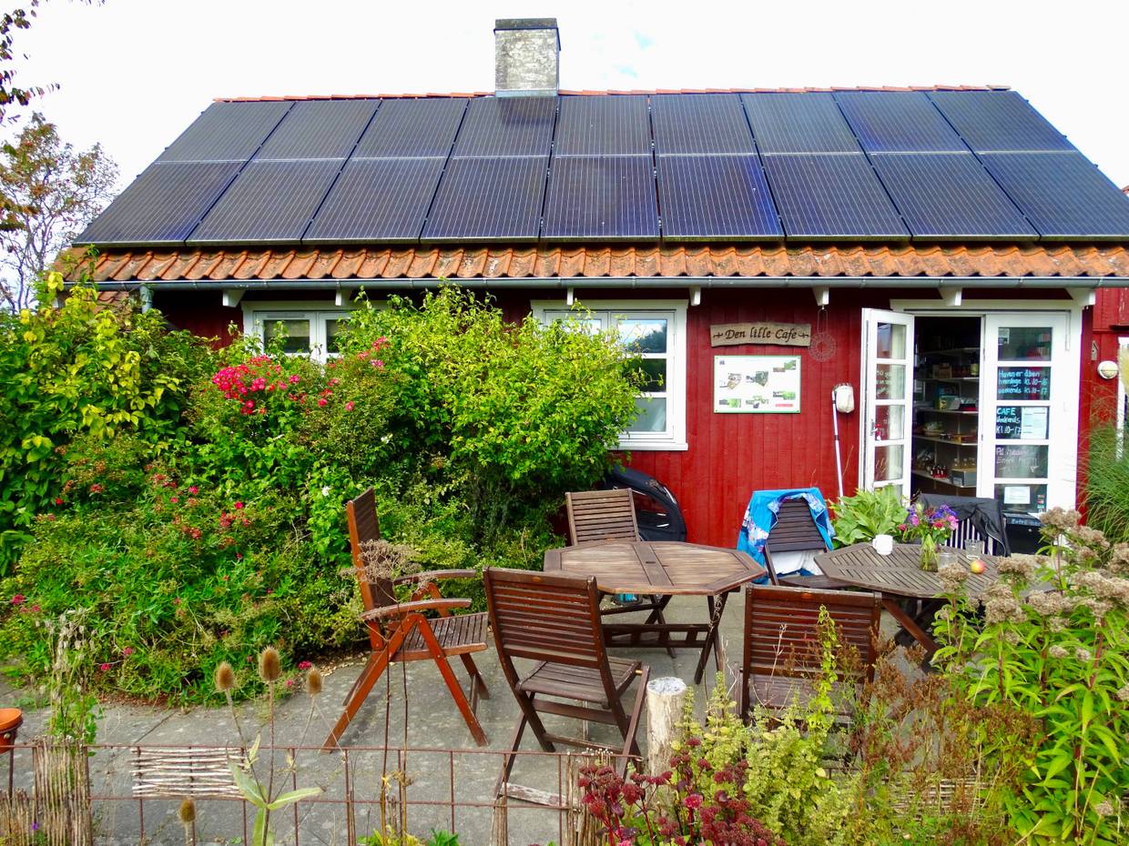 Rote Holzhütte mit Sitzplätzen vor der Tür