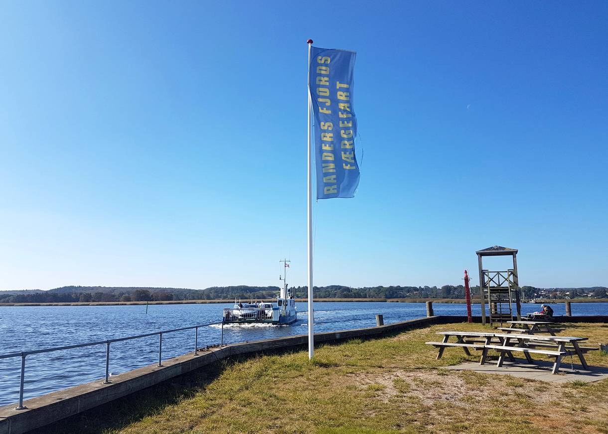 Kleine Fähre auf dem Fjord, am Anleger Spielgerüste und Picknicbänke