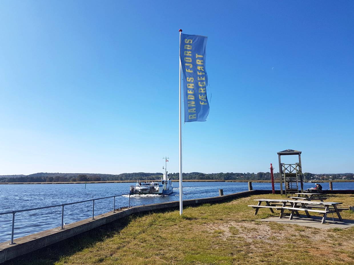 Kleine Fähre auf dem Fjord, am Anleger Spielgerüste und Picknicbänke