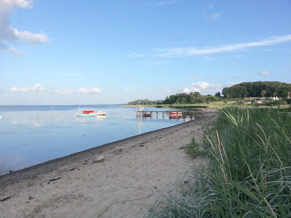 Schmaler, steiniger Sandstrand im Abendlicht