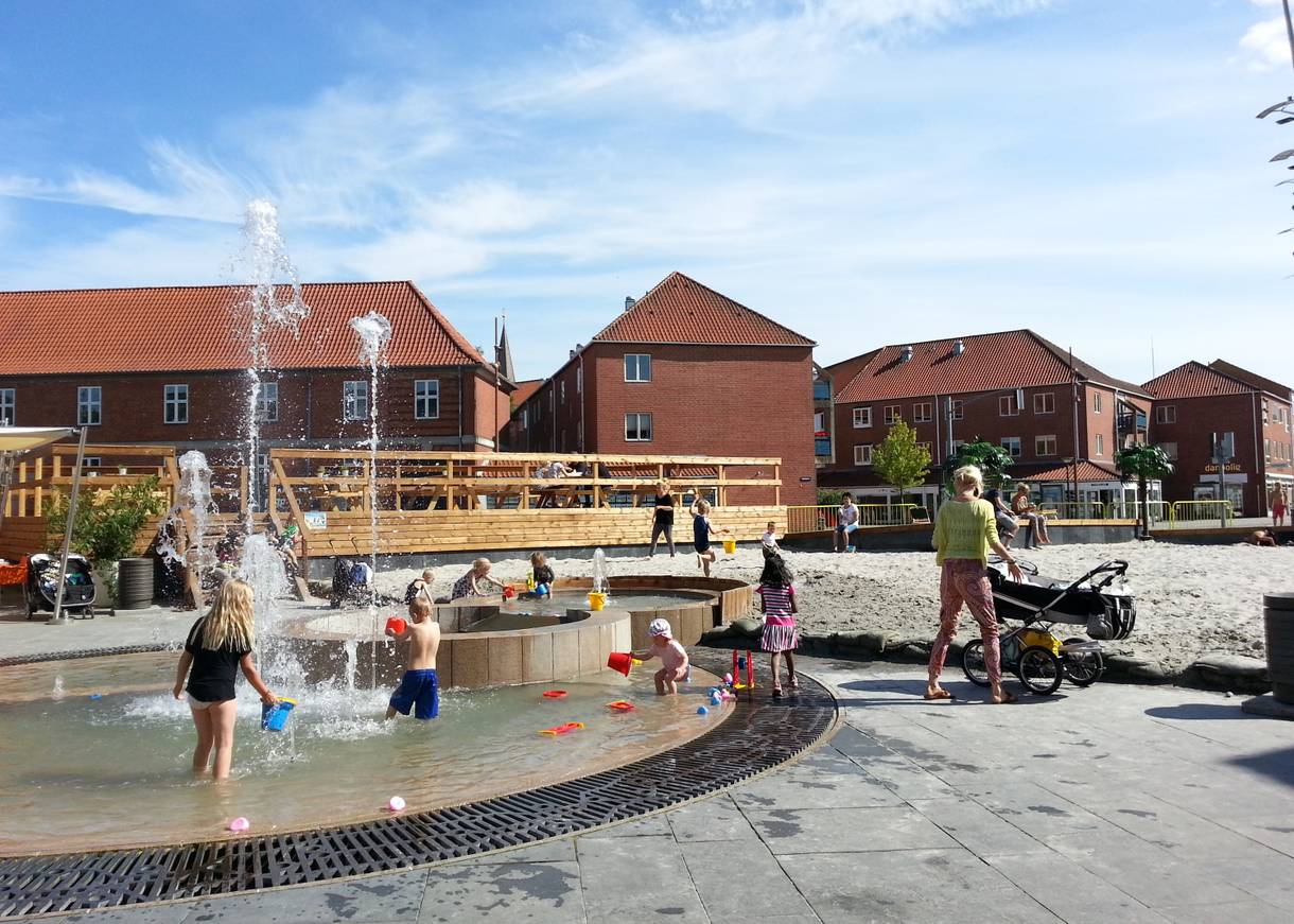 Spielende Kinder en einem Brunnen in der Stadt