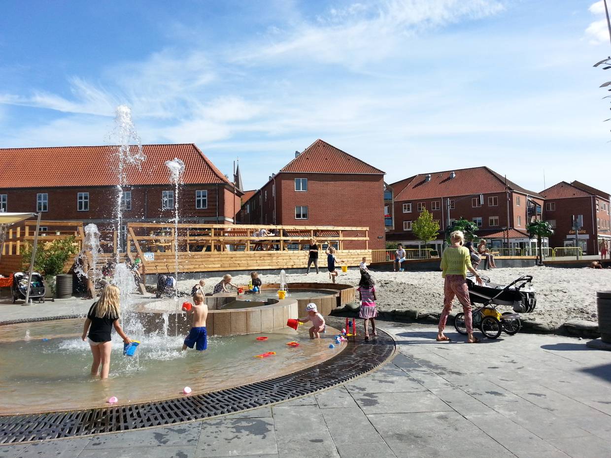 Spielende Kinder en einem Brunnen in der Stadt